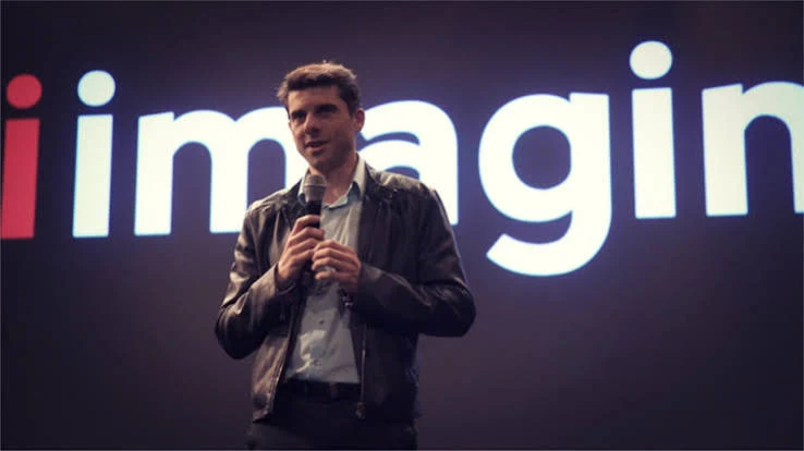 Adam Radly in front of our iImagine logo at his event in New York