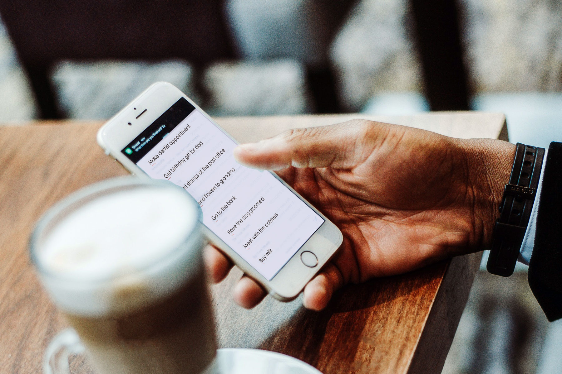 Man drinking coffee using Do+ app on a mobile phone