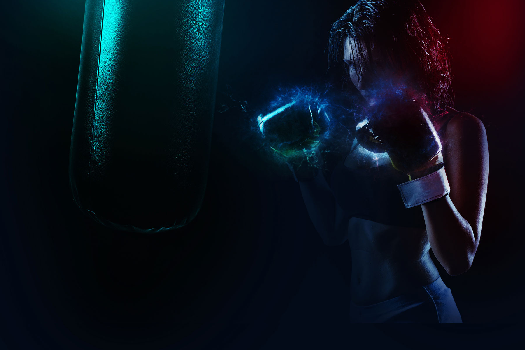 Woman with boxing gloves on dark background